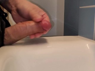 Fast jerk-off! Small uncut cock get jerked in public bathroom and cums all-over the sink.